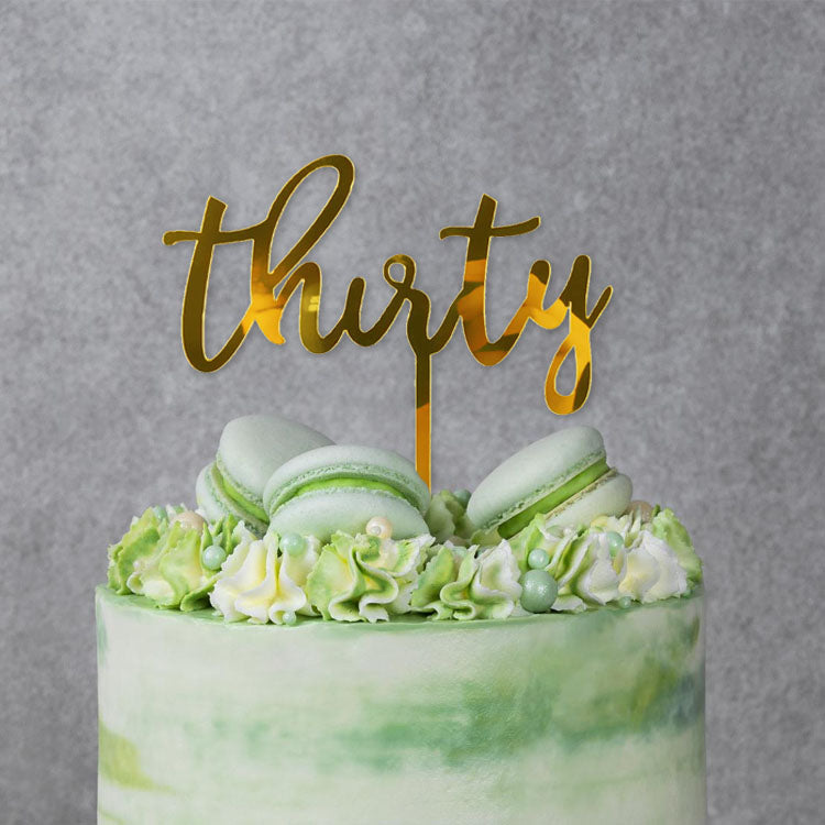Gold acrylic cake topper with the text 'thirty,' perfect for 30th birthday celebrations.