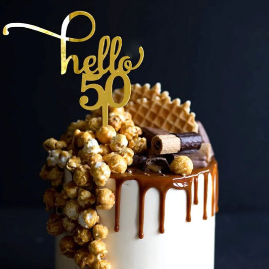 Gold acrylic cake topper shaped as 'hello 50' for a milestone birthday celebration cake