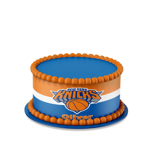 New York Knicks edible cake strips with blue and orange wrap design on frosted cake flat lay